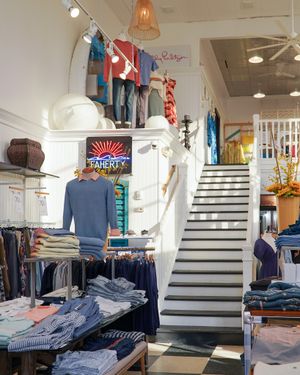 Retail clothing store interior with white stairs and neatly folded denim displays.