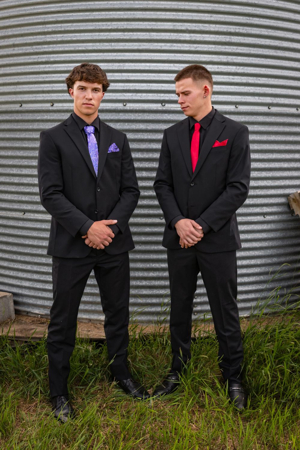 two grads stand together smiling.