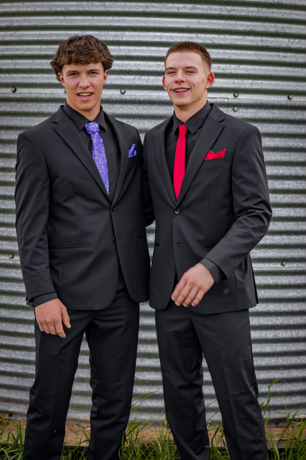 two grads stand together smiling.
