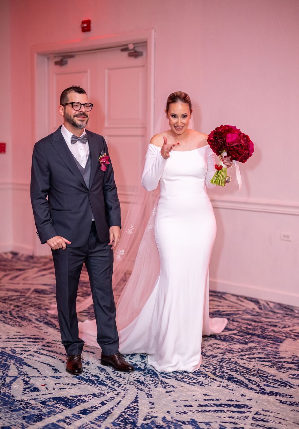 Formal wedding portrait showing couple in classic black suit and white off-shoulder gown.