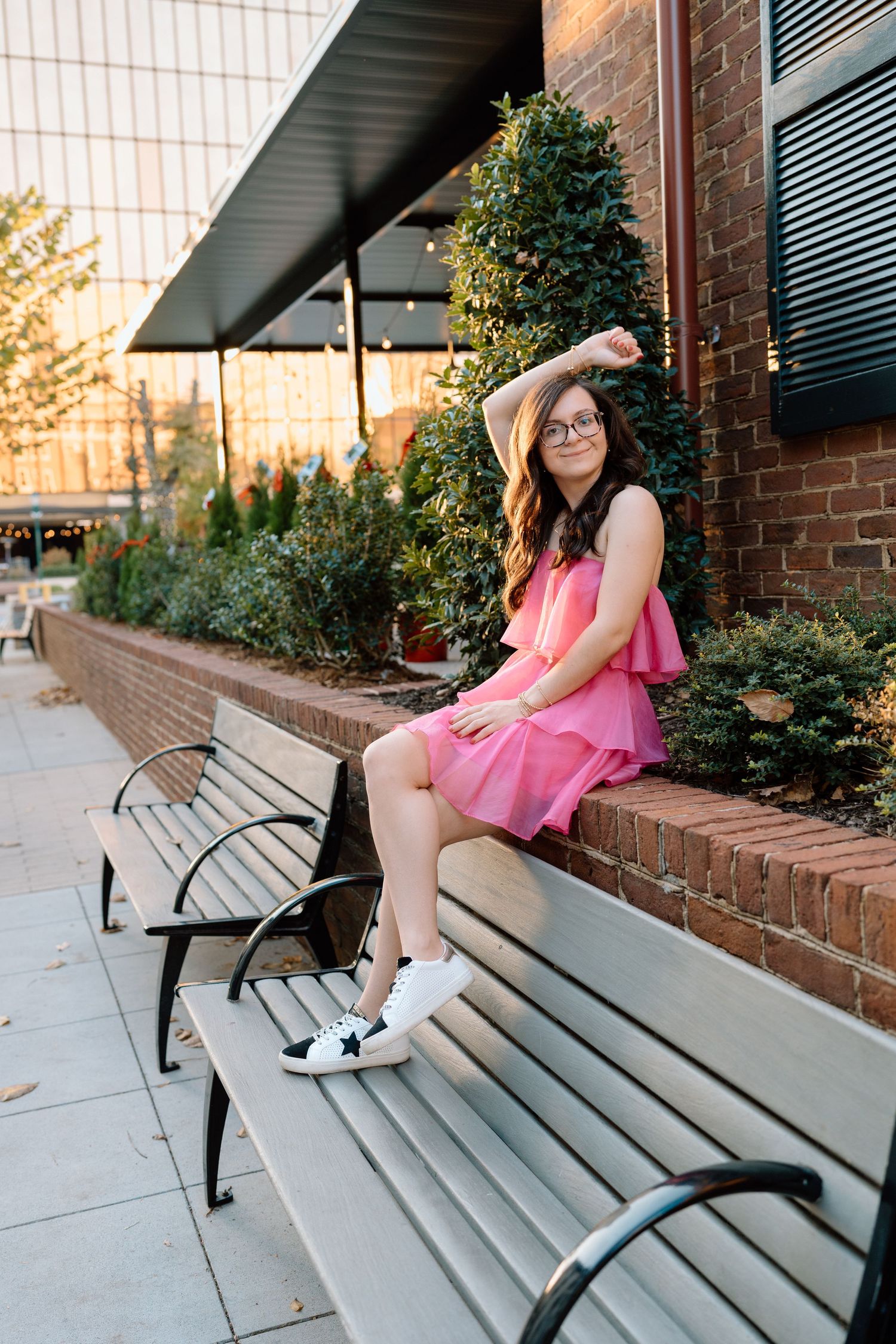 Artistic portraits on a wooden bench showing various poses in a pink dress against brick architecture. Chattanooga Senior Photographer