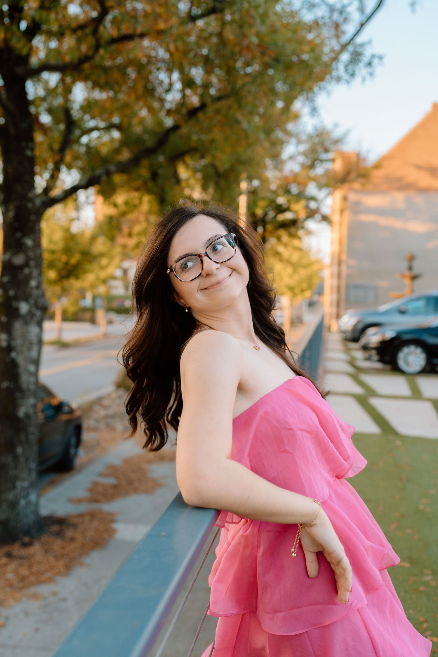 A series of playful poses in a pink ruffled dress against a warm autumn backdrop. Chattanooga Senior Photographer