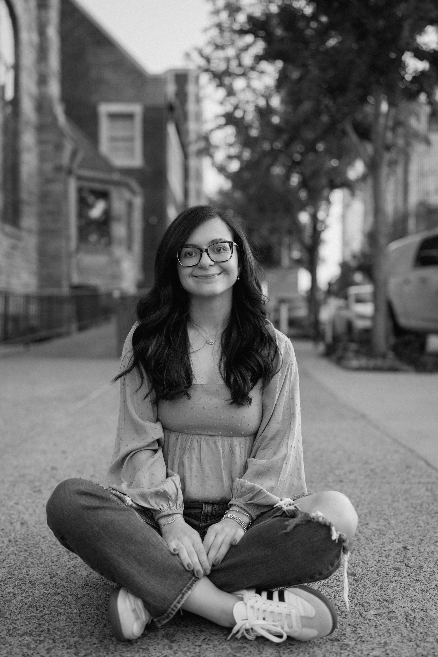 Relaxed outdoor portraits in casual attire sitting on pavement. Chattanooga Senior Photographer