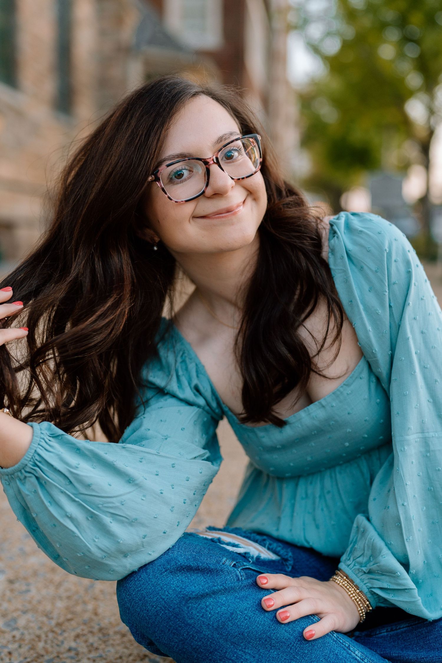 Playful poses in a turquoise top against brick architecture. Chattanooga Senior Photographer