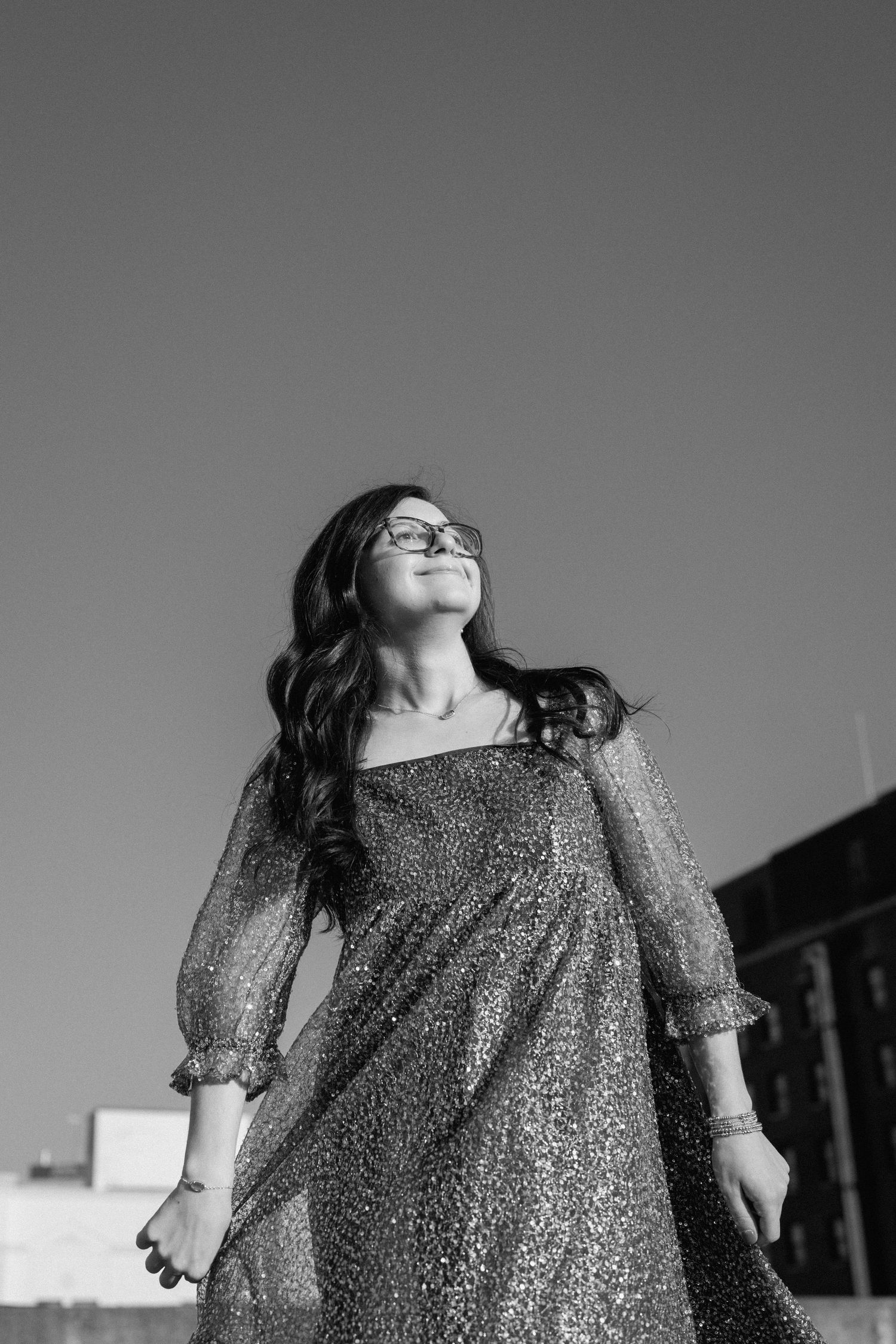 Dramatic black and white photo of person in glittery dress twirling on rooftop. Chattanooga Senior Photographer