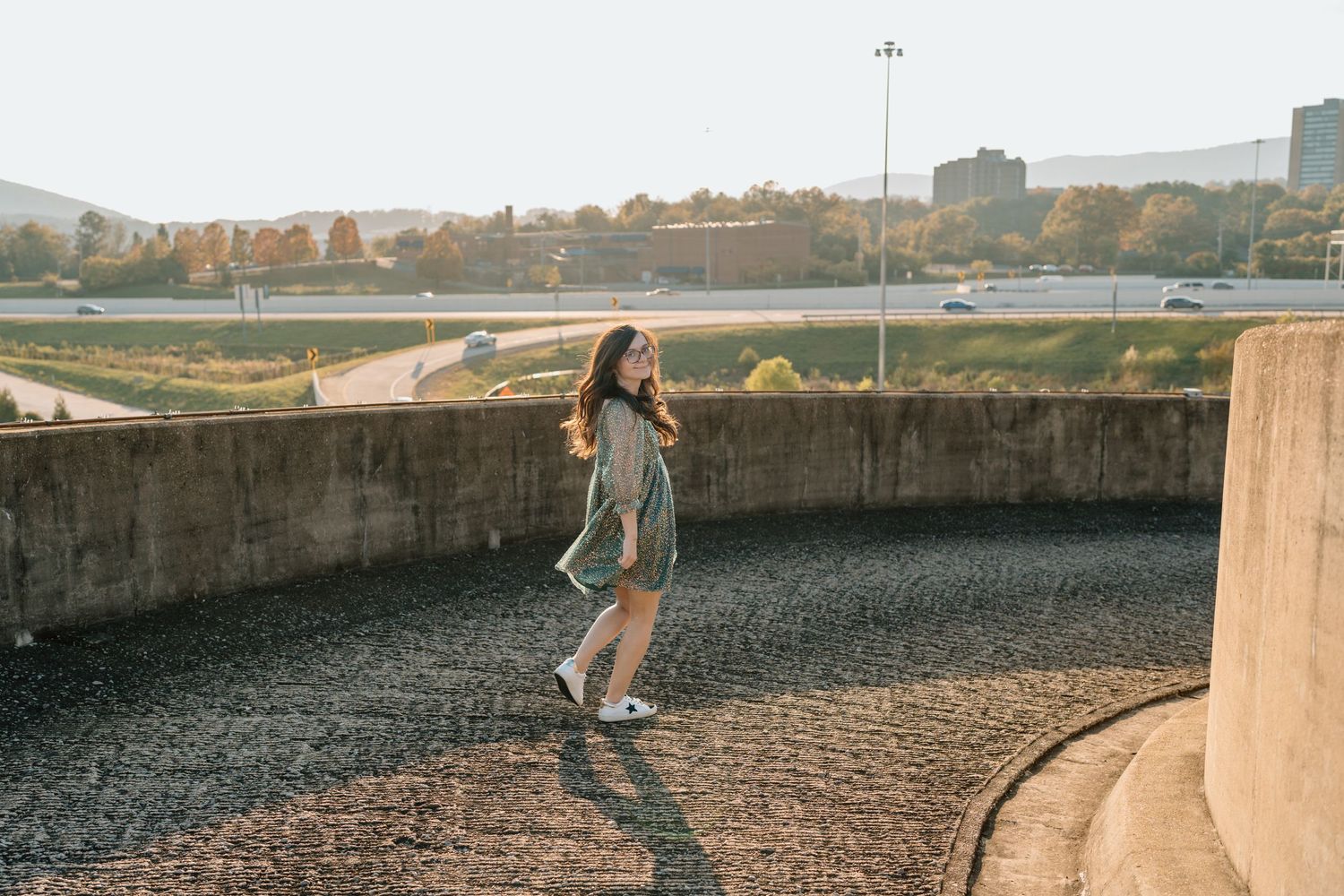 Silhouette of person walking along curved concrete barrier at sunset. Chattanooga Senior Photographer