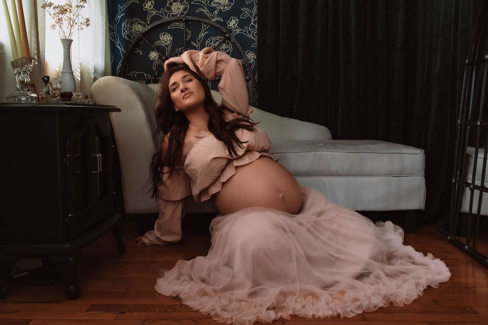Pregnancy portrait photographed naturally in a soft, private studio setting