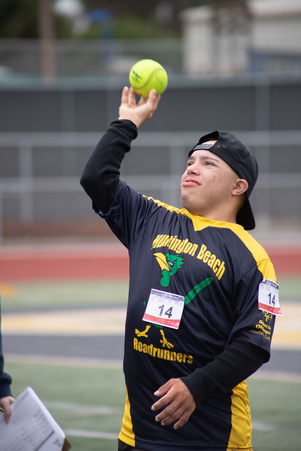 Athlete preparing to throw a softball during a track and field event.
