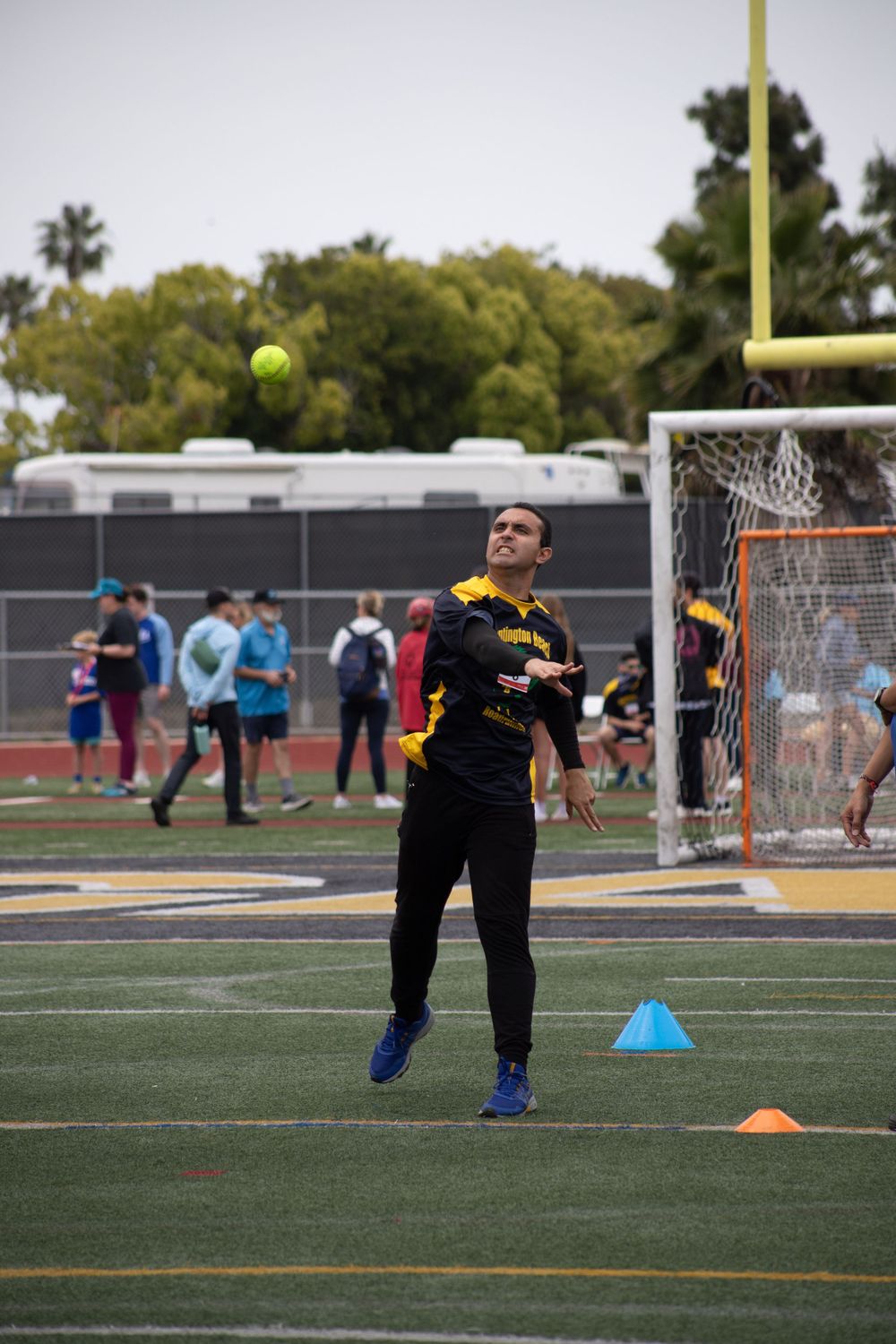 Athlete practicing ball throwing drills on a sports field with training cones.