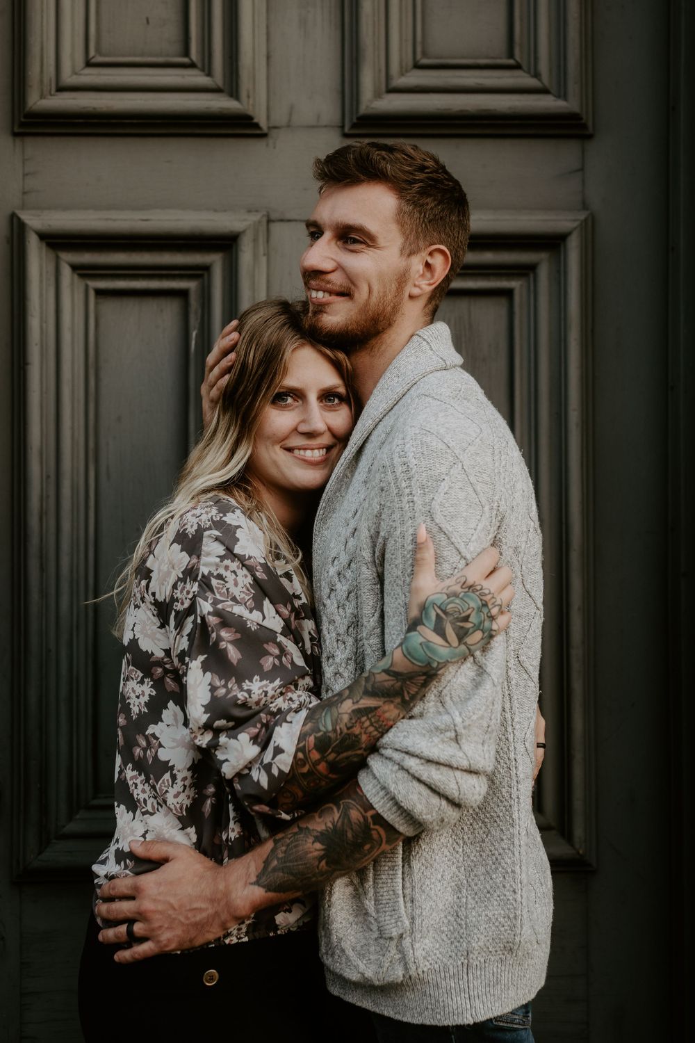 couple embracing in front of an old painted victorian style door