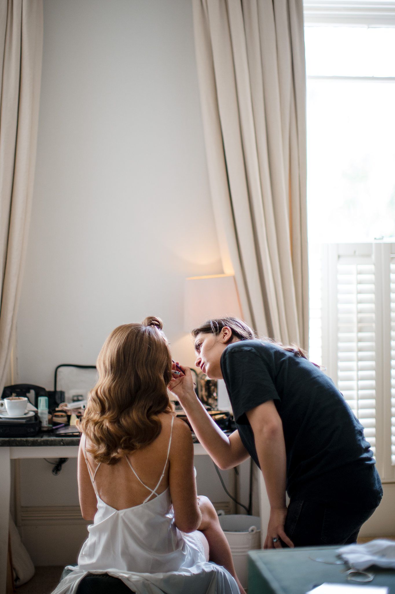 Professional wedding makeup artist applying cosmetics on model in bright bedroom with natural light, The Westin Nova Scotian, Halifax.