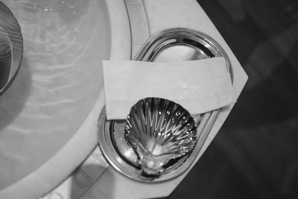 Black and white photo of a silver shell-shaped baptismal font.