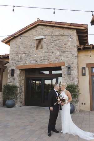 Elegant stone venue entrance with Mediterranean architectural details creates romantic wedding backdrop.