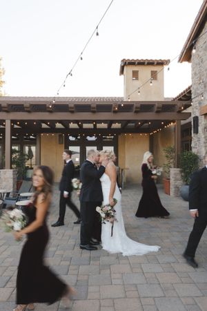 Wedding ceremony in progress at a rustic stone venue with string lights and guests in formal attire.