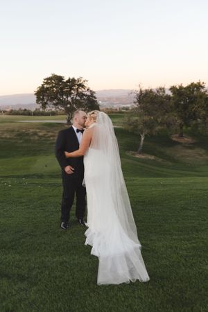 Romantic sunset moment on a green golf course with mountains in the distance.
