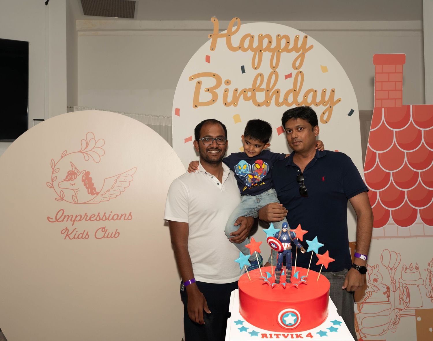 Family gathering around a decorated birthday cake at Impressions Kids Club.