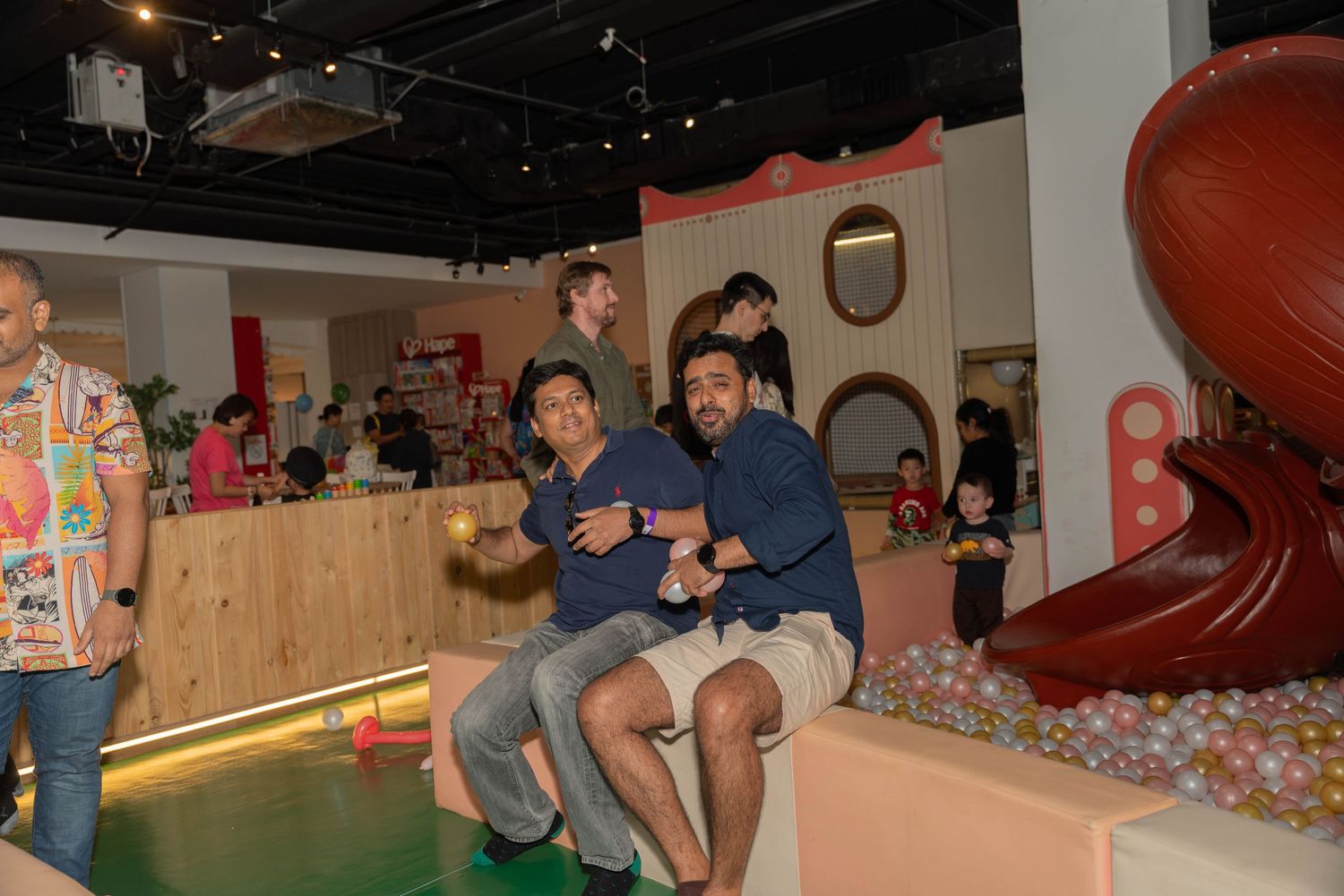 People enjoying themselves at an indoor party venue with colorful decorations.