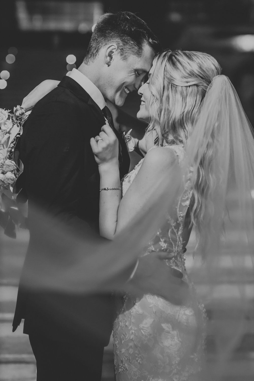 Intimate black and white portrait of newlyweds sharing a tender moment.