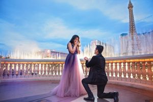 A romantic proposal moment at twilight in front of the Eiffel Tower with illuminated fountains in Paris.