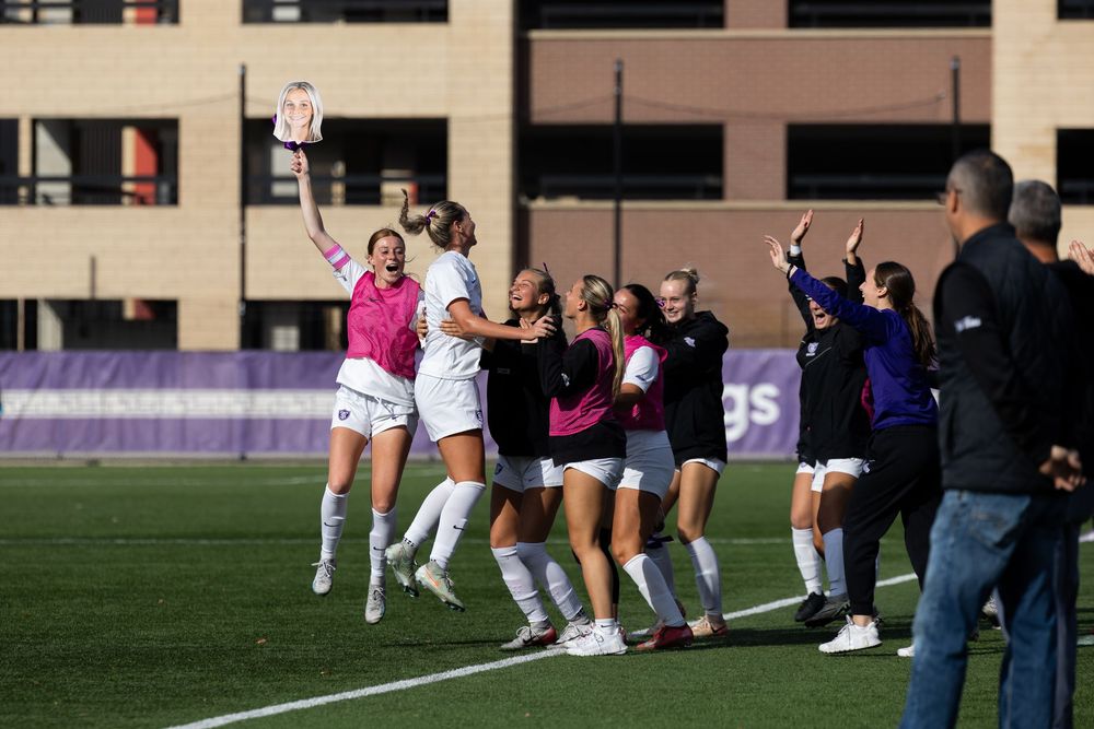 Players celebrate on a sports field after a dramatic play during an outdoor athletic competition.