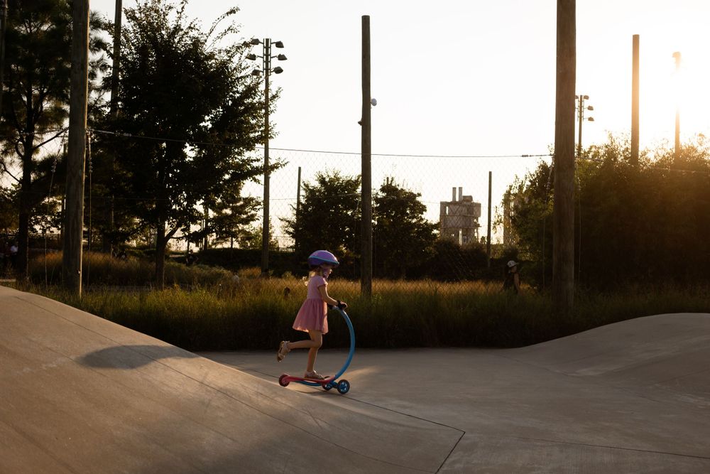 Child rides Scooter at Skate Park in Tulsa Parks Gathering Place. Taken by Tulsa Photographer Cristin Franks