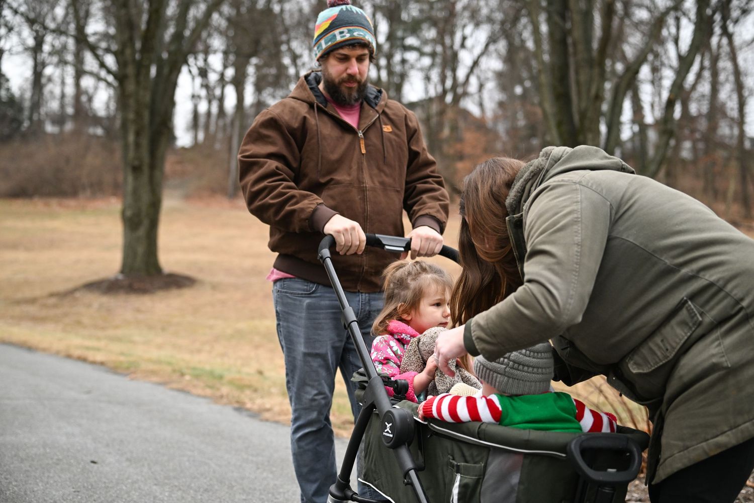 Leaving the park, Amber tucks Emma and baby Nolan into their wagon as Evan waits to push the kids home