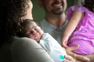 Tender family moment captured in soft lighting as they hold each other close.
