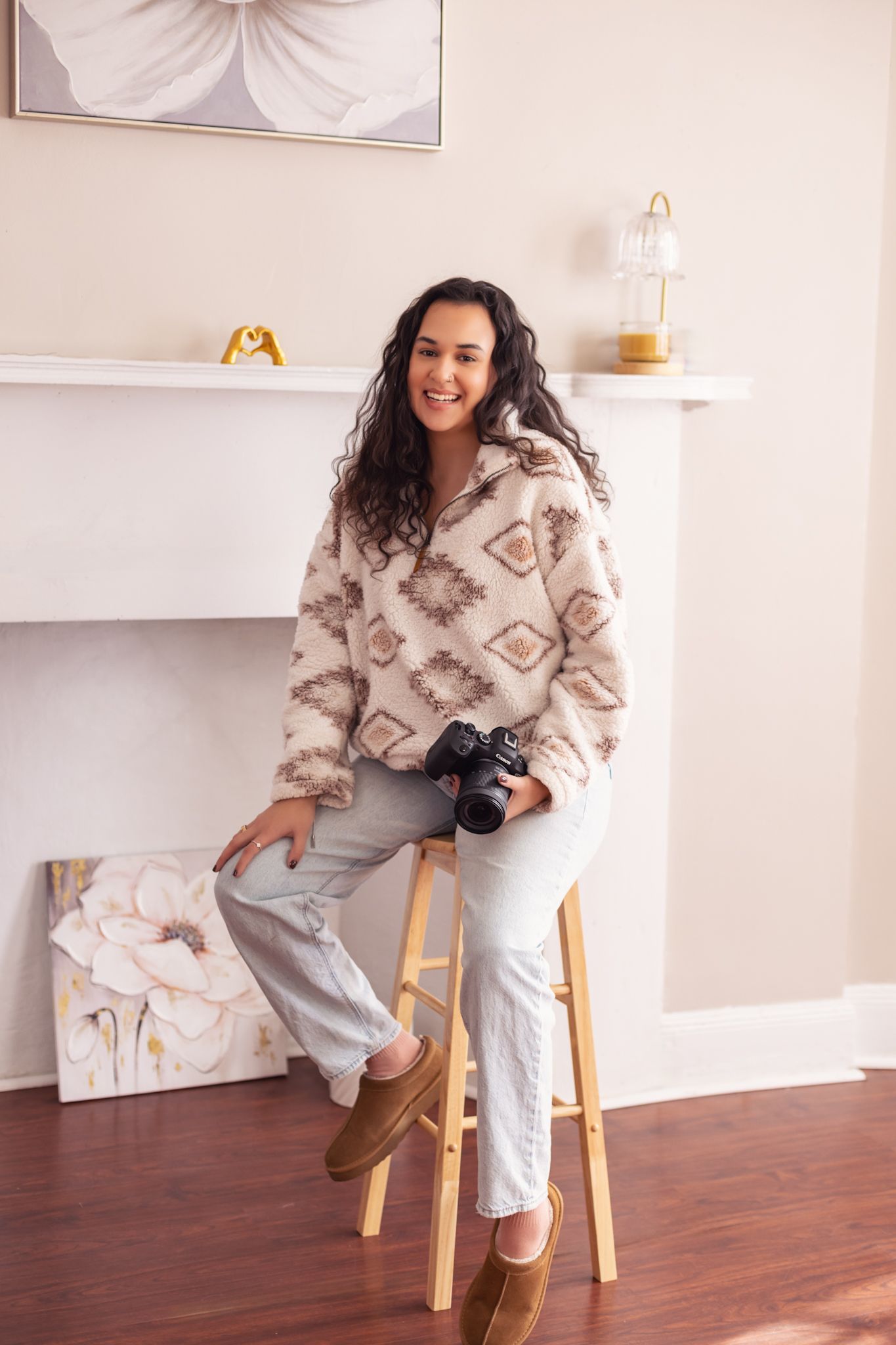 Lifestyle personal branding photo — woman sitting on a tan couch in a bright, minimalist studio setting.
