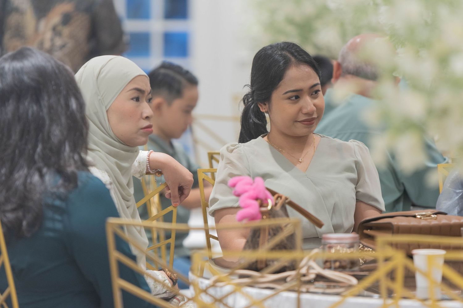 Guests enjoying a meal at an elegant reception with gold chairs.