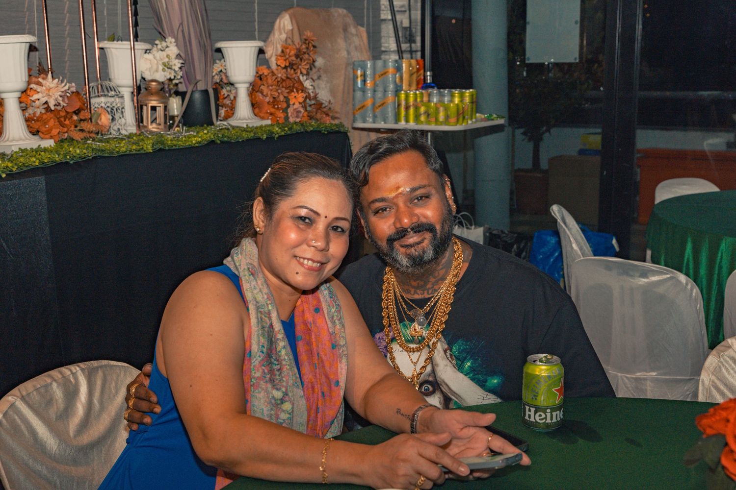 Couple enjoying themselves at a festive party with decorative lighting.