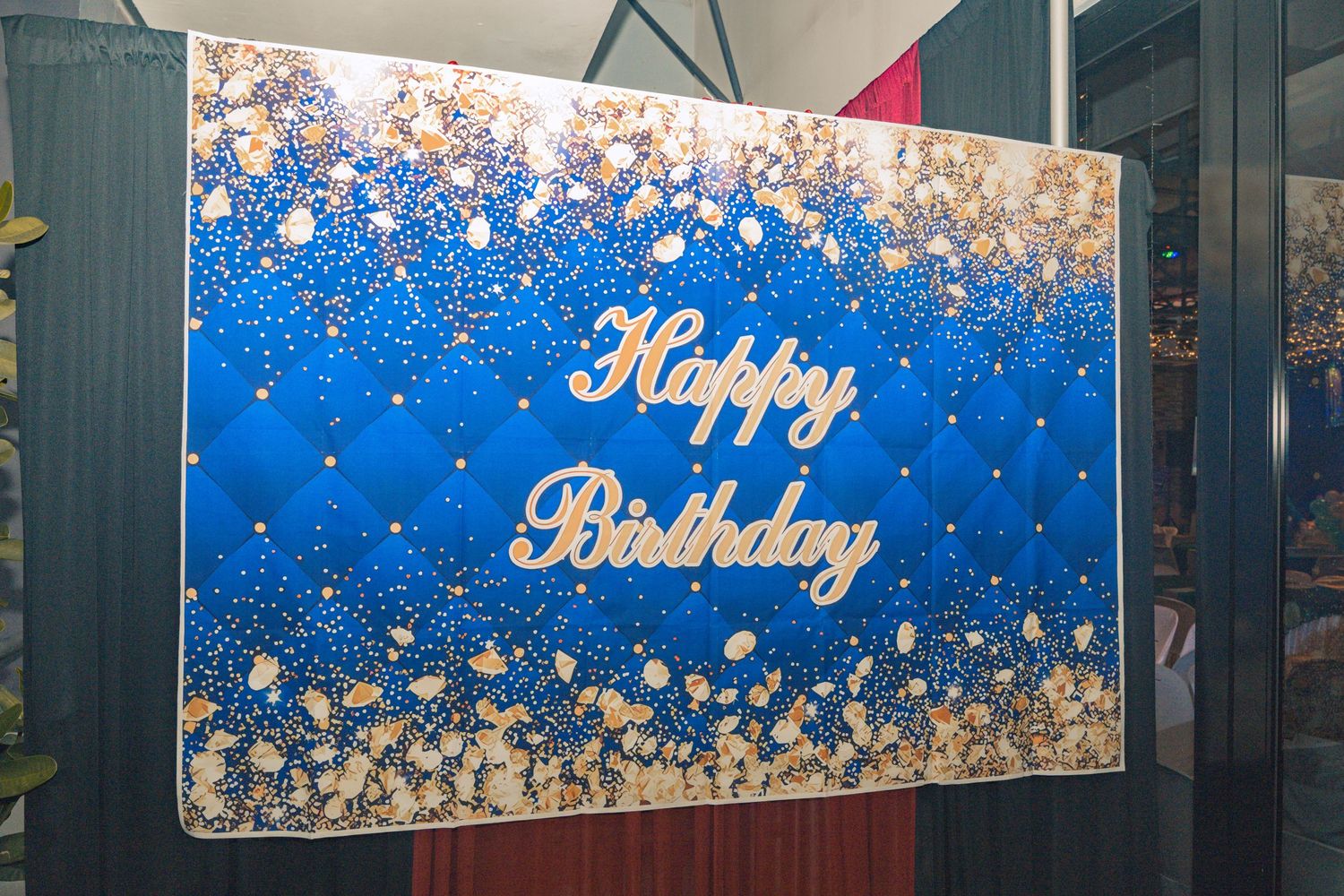 A blue and silver Happy Birthday sign with sparkly decorative elements.