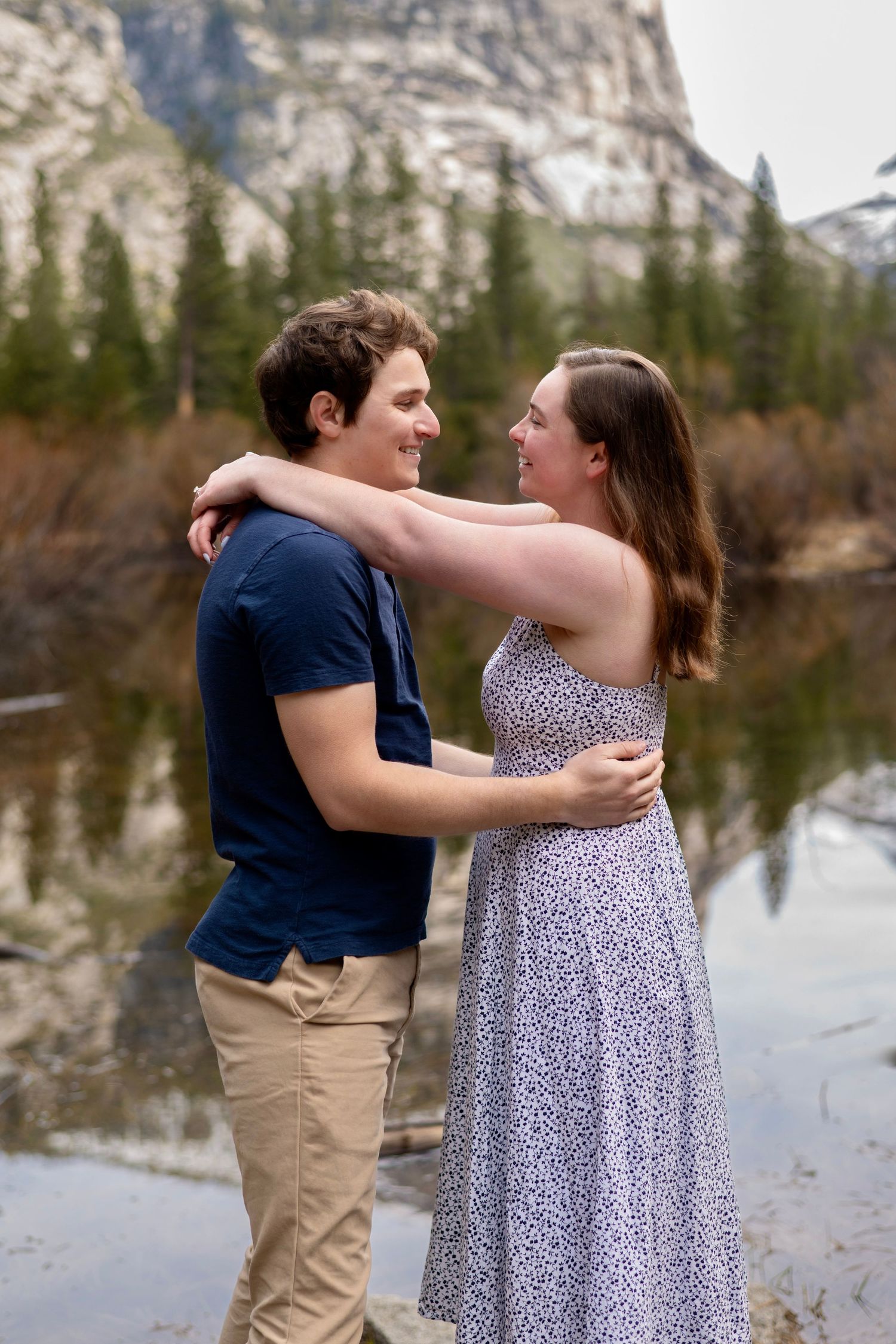 A couple embracing in the reflection of cliffs at Mirror Lake, Yosemite
