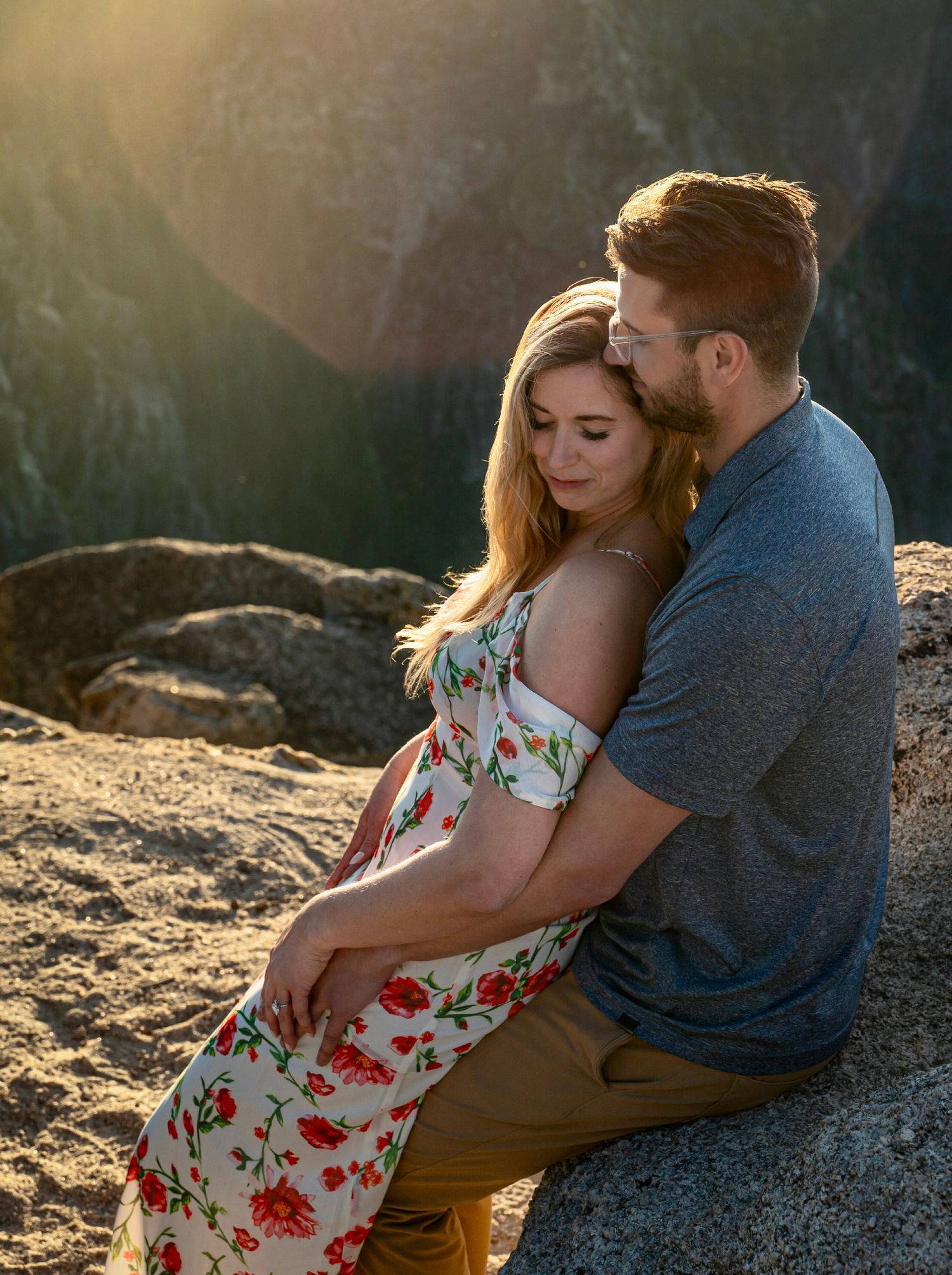 An embracing newly engaged couple on Taft Point Yosemite during golden sunset hour