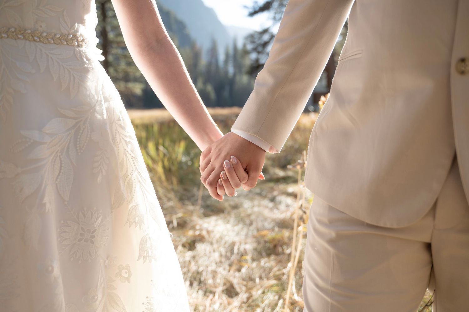 A bride and groom holding hands in Yosemite