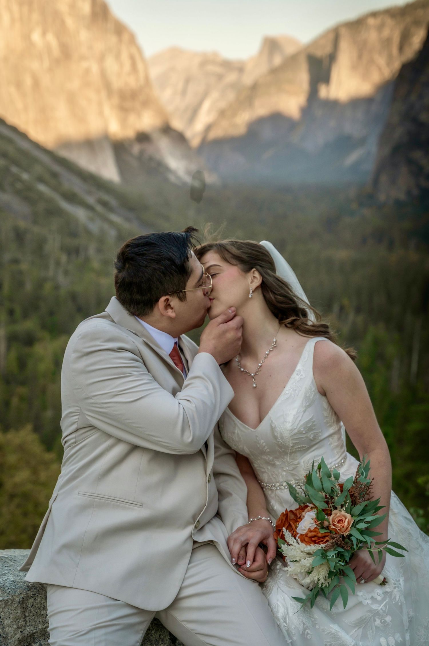 A bride and groom kissing in front of Tunnelview, Yosemite, California