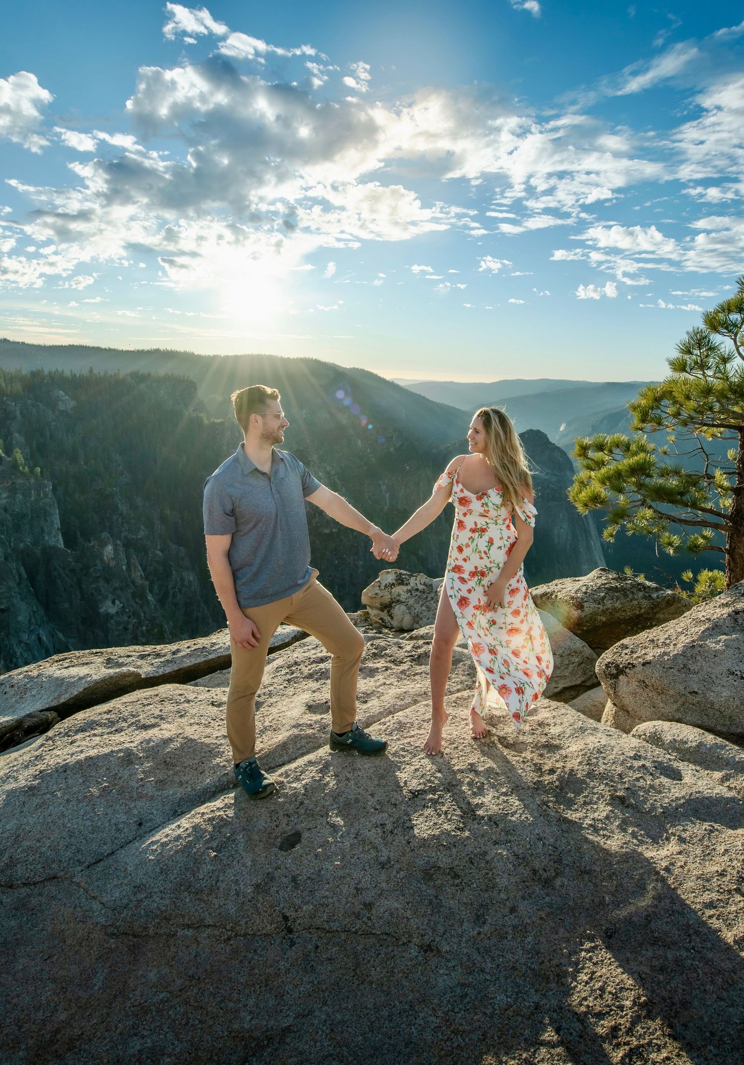 An embracing newly engaged couple on Taft Point Yosemite with a blue sky