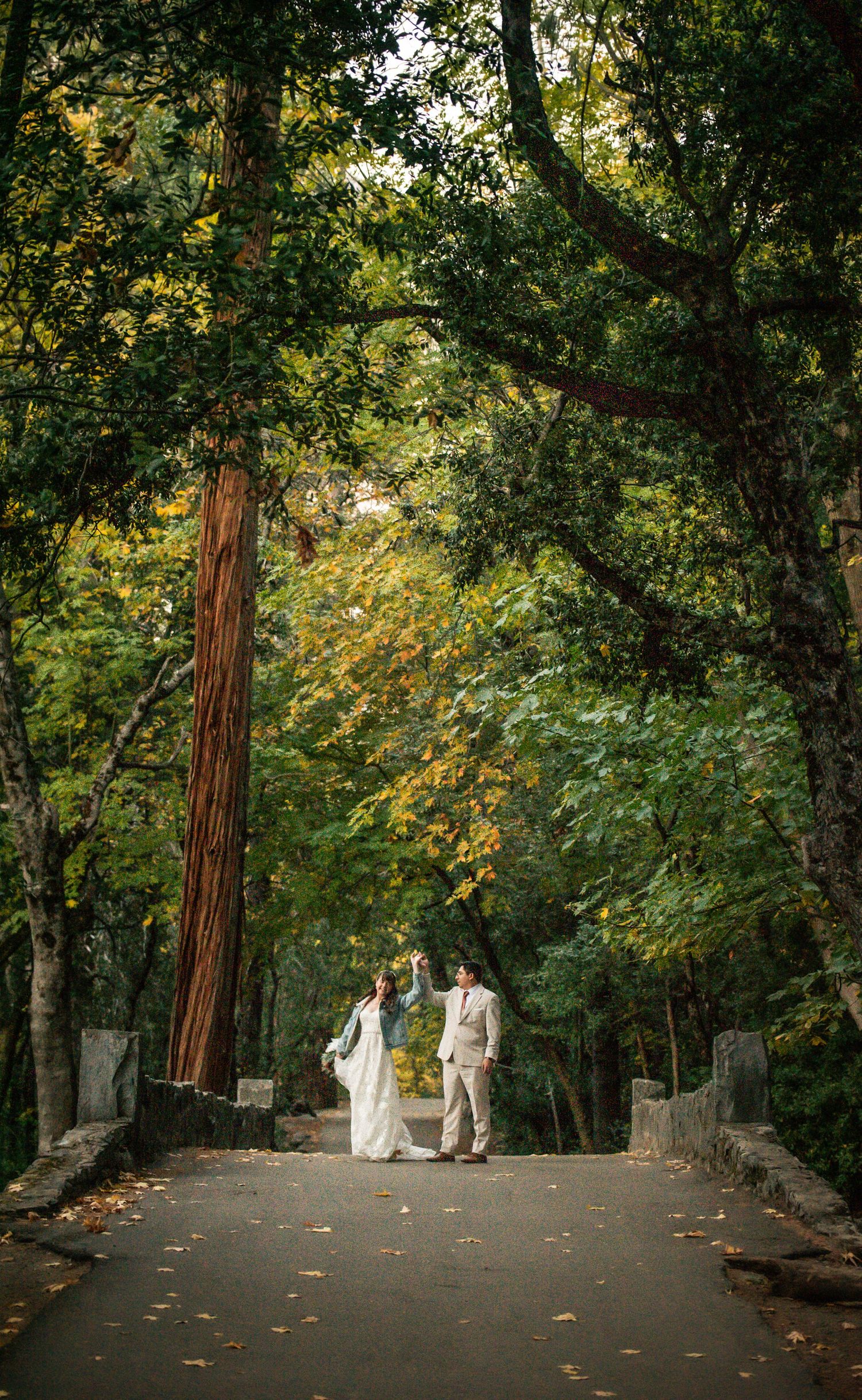 A wedded couple dance on a bridge by Yosemite Falls in Yosemite, California