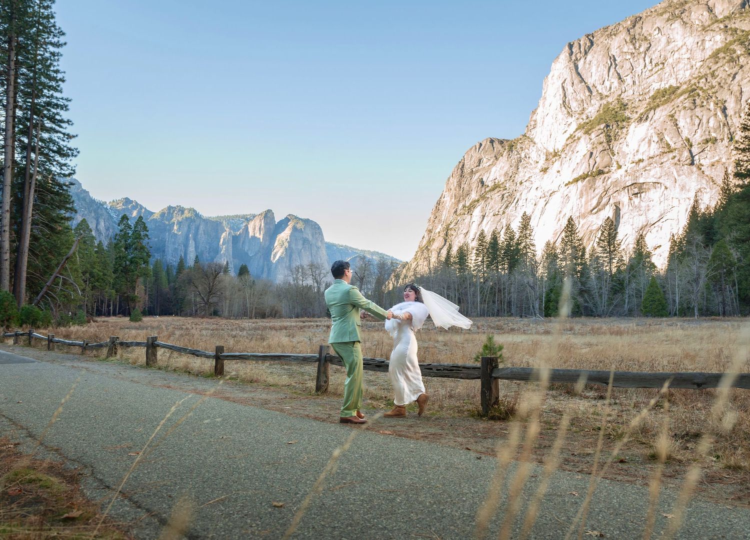 A bride and groom spinning in front of cliffs in Yosemite