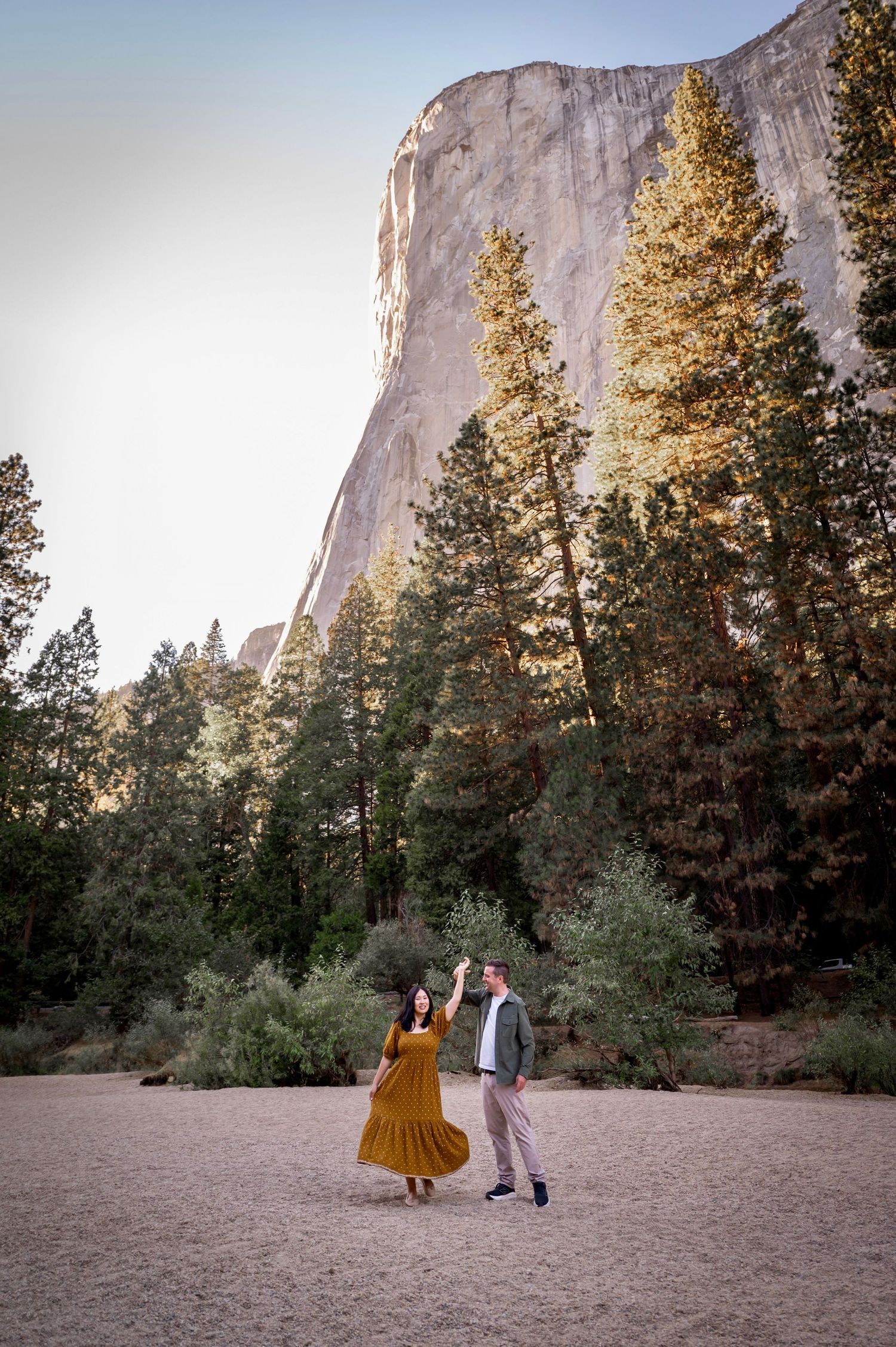 a newly engaged couple dance by the river in front of El Capitan, Yosemite, California