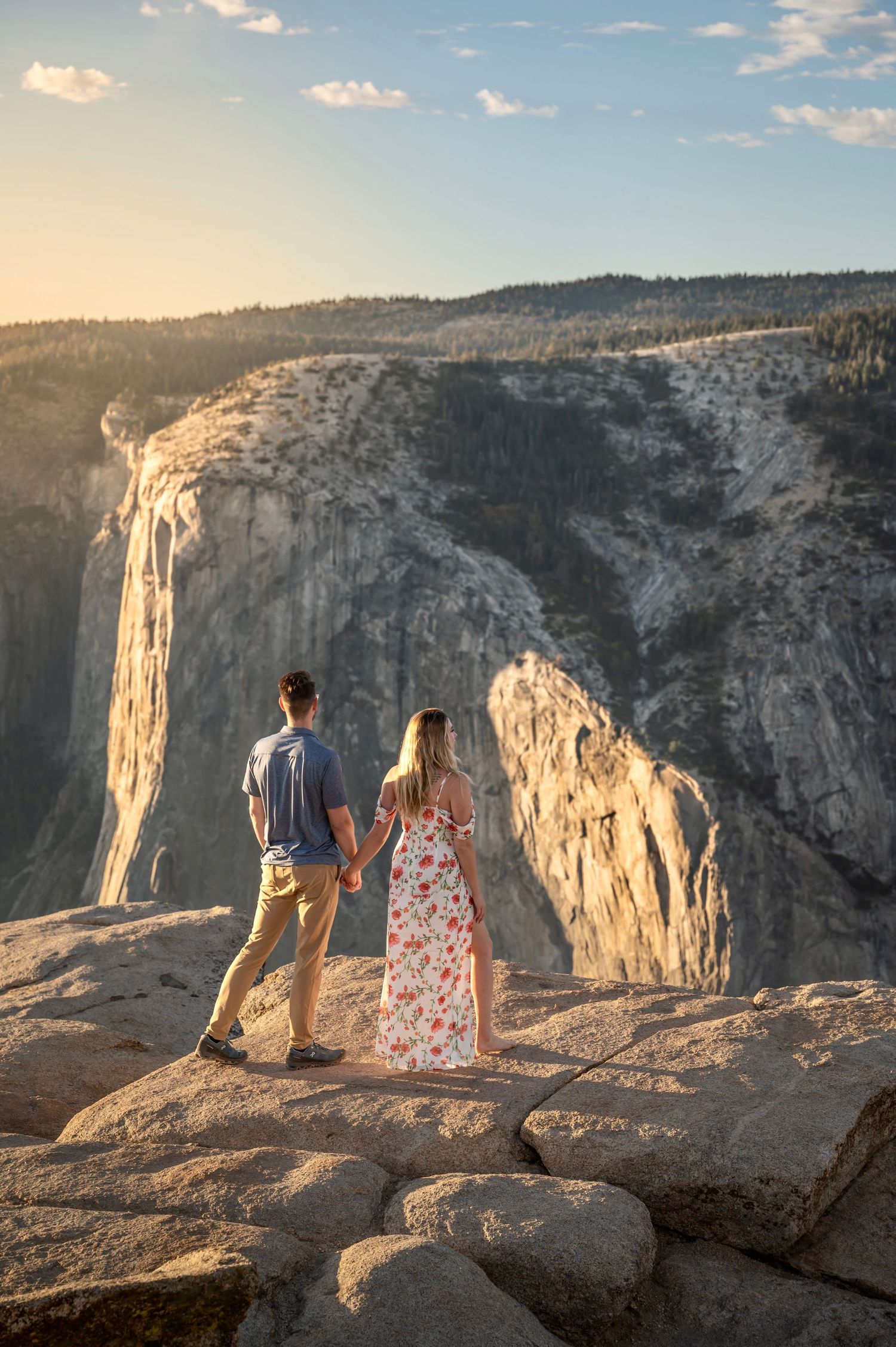 A newly engaged couple hold hands on Taft Point, Yosemite, California