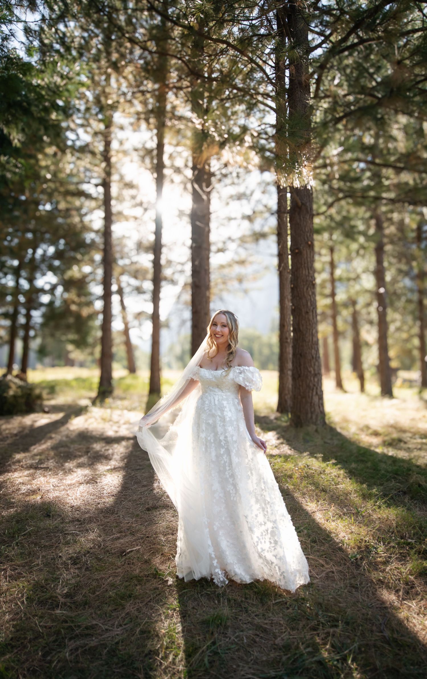 A beautiful bridal portrait with soft backlight in the trees at her wedding at Yosemite Chapel