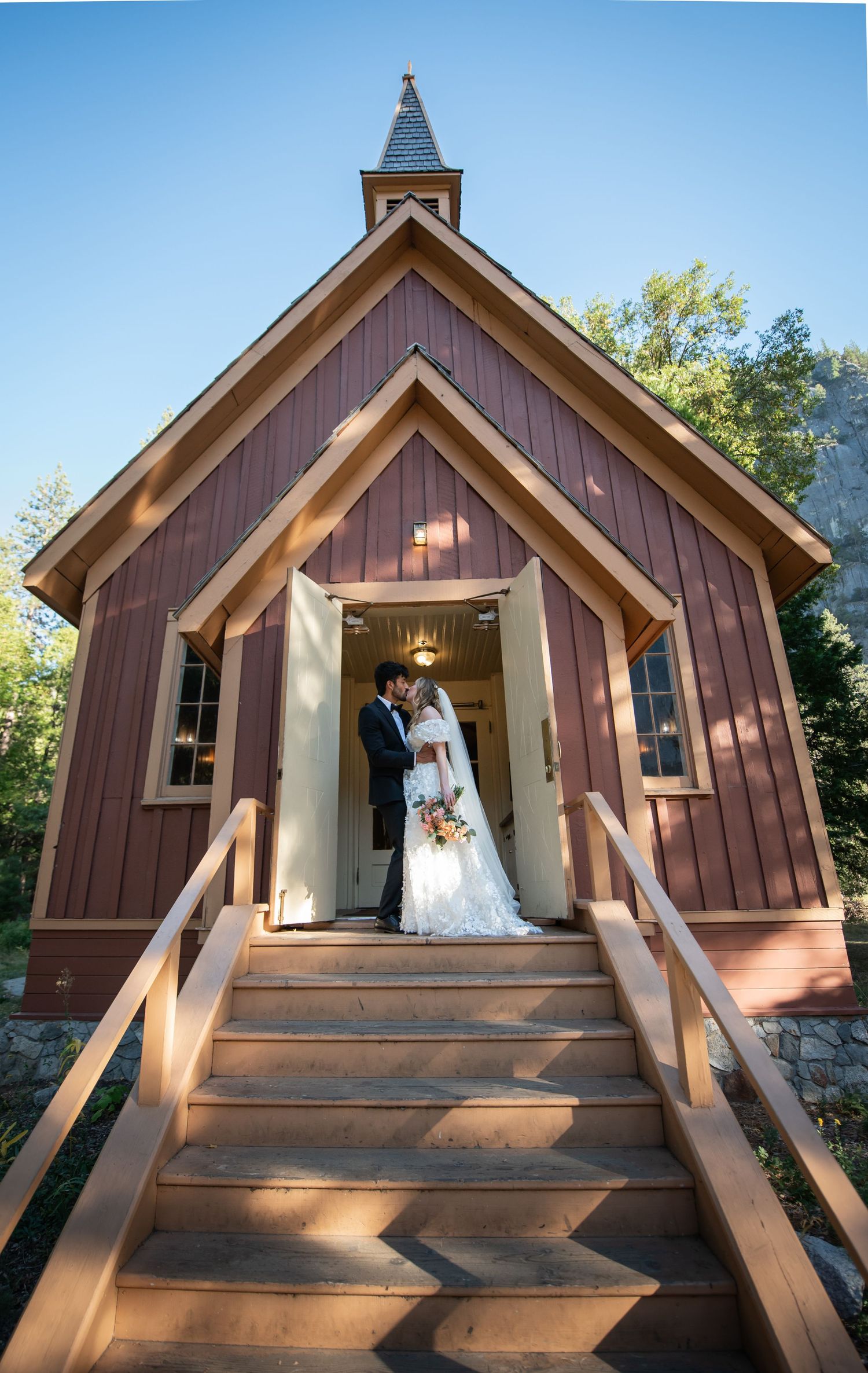 A beautiful bride and groom in front of the church at their wedding at Yosemite Chapel