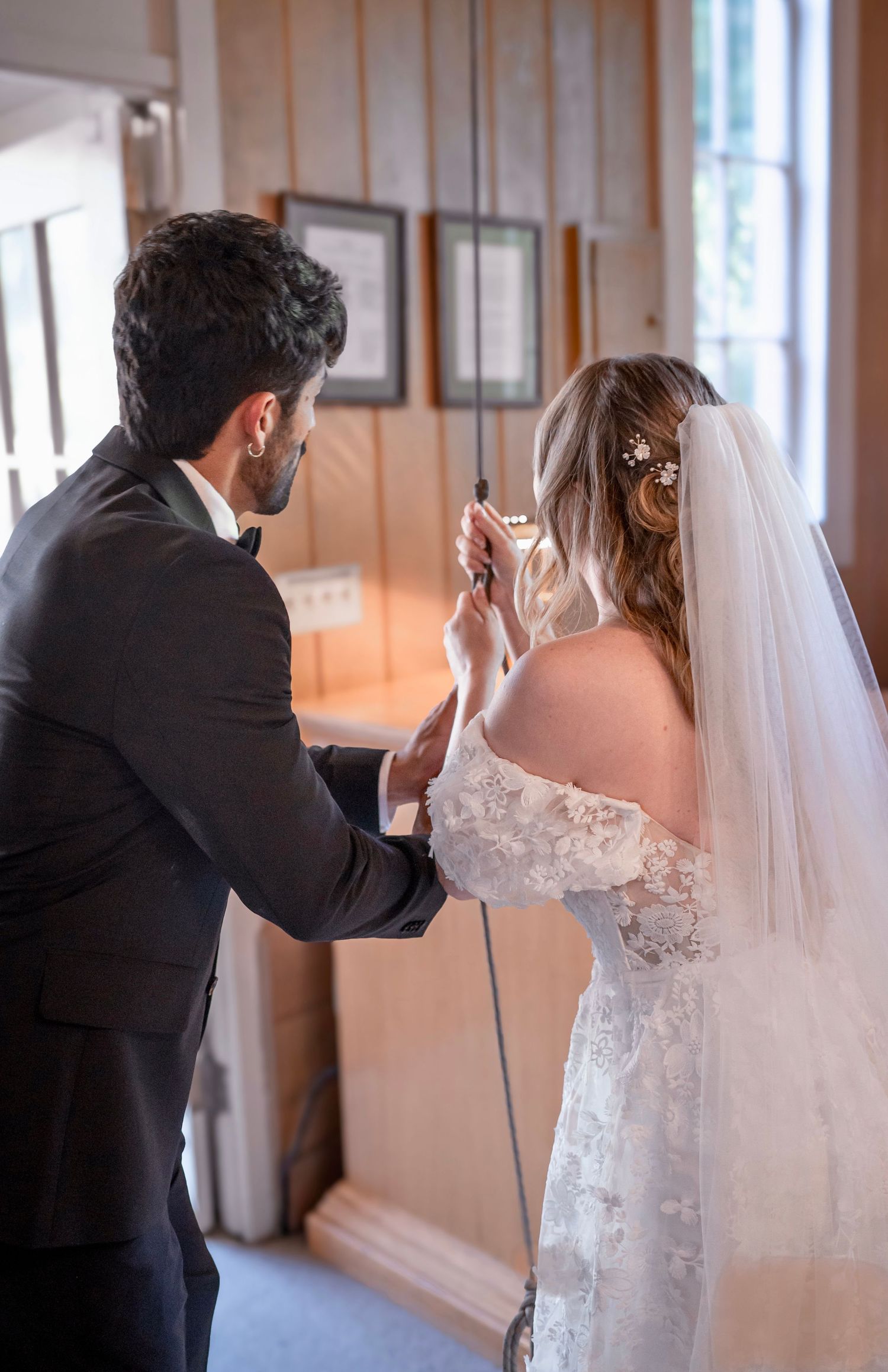 A beautiful bride and groom ringing the bell at their wedding at Yosemite Chapel