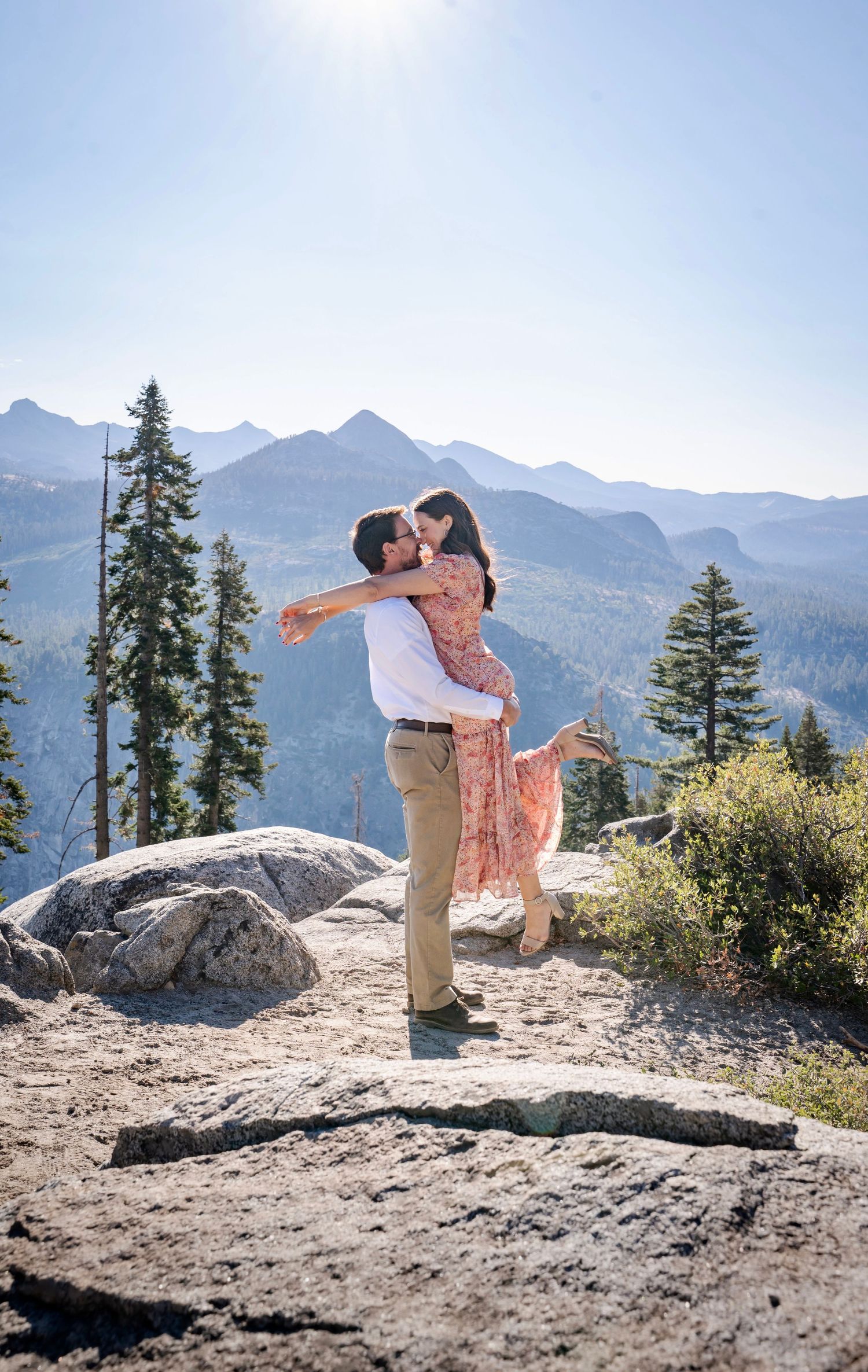 a beautiful engaged couple with their dog in Yosemite as a backdrop, at Glacier Point and Half Dome in the background