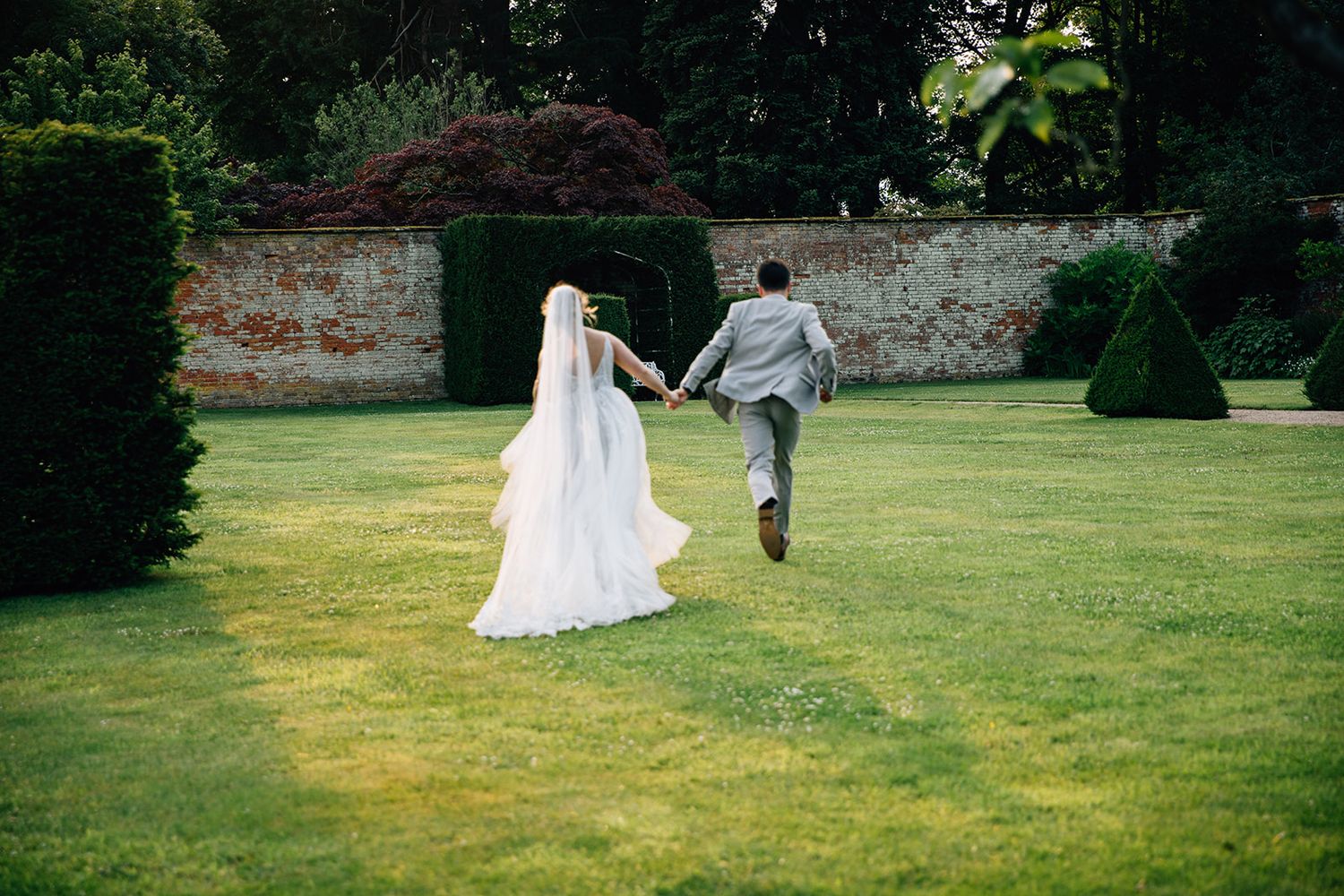 A couple shares a happy, candid moment together in a park setting.