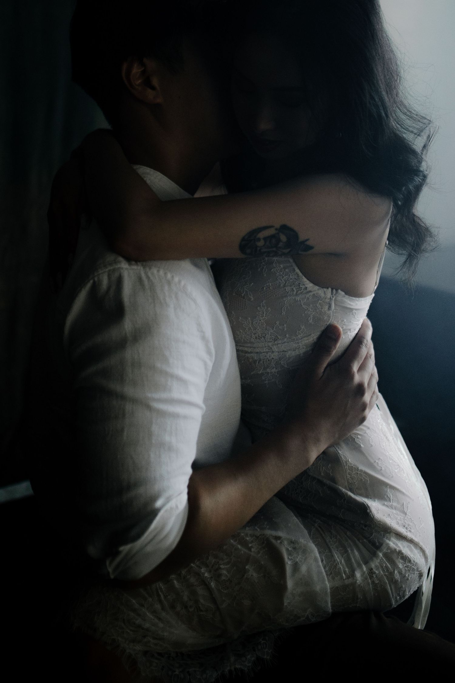 Artistic series showing someone in white clothing against a dark background in dramatic lighting.