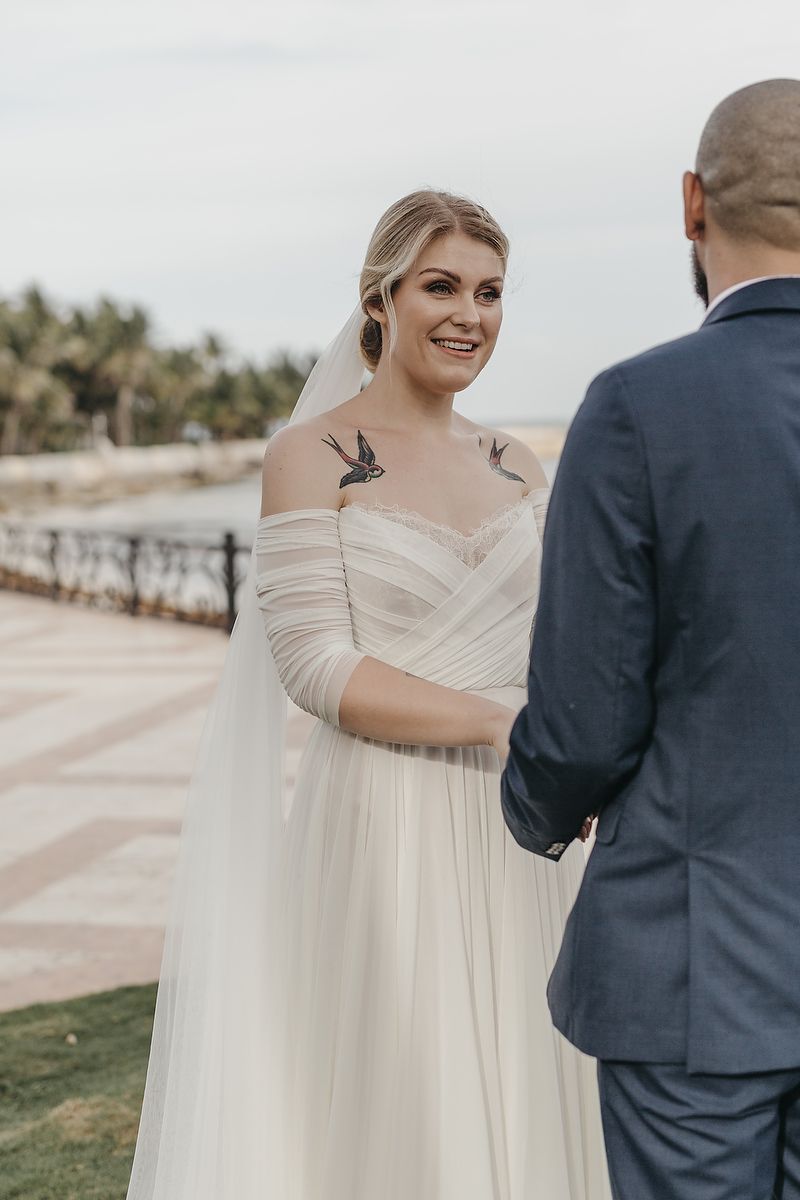 A couple shares a tender moment during their wedding ceremony overlooking a scenic outdoor landscape.
