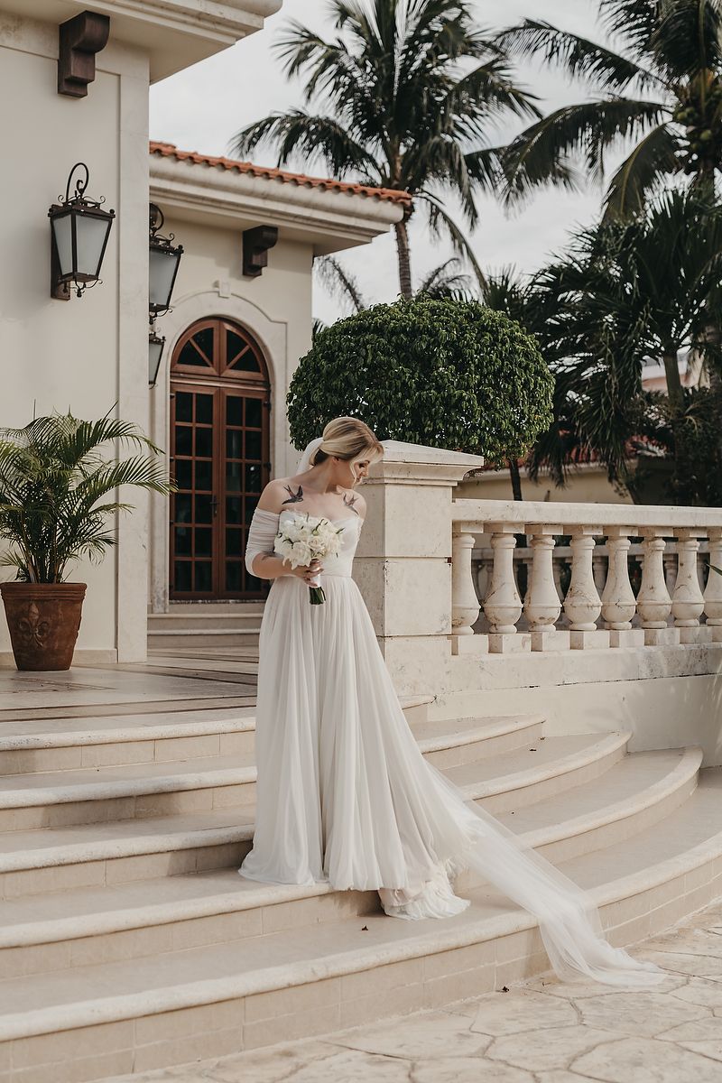Bride walking down elegant staircase at Villa la Joya Playa del Carmen Riviera Maya wedding photographer.