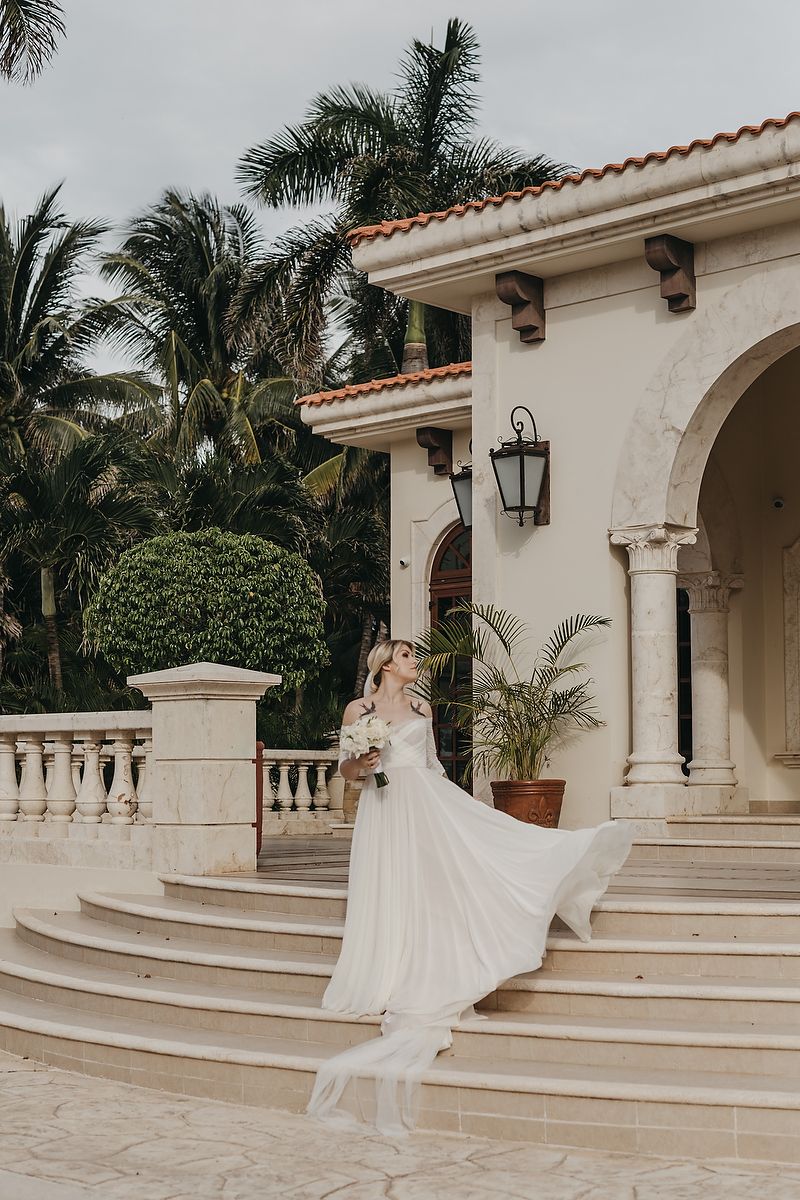 Bride walking down elegant staircase at Villa la Joya Playa del Carmen Riviera Maya wedding photographer.