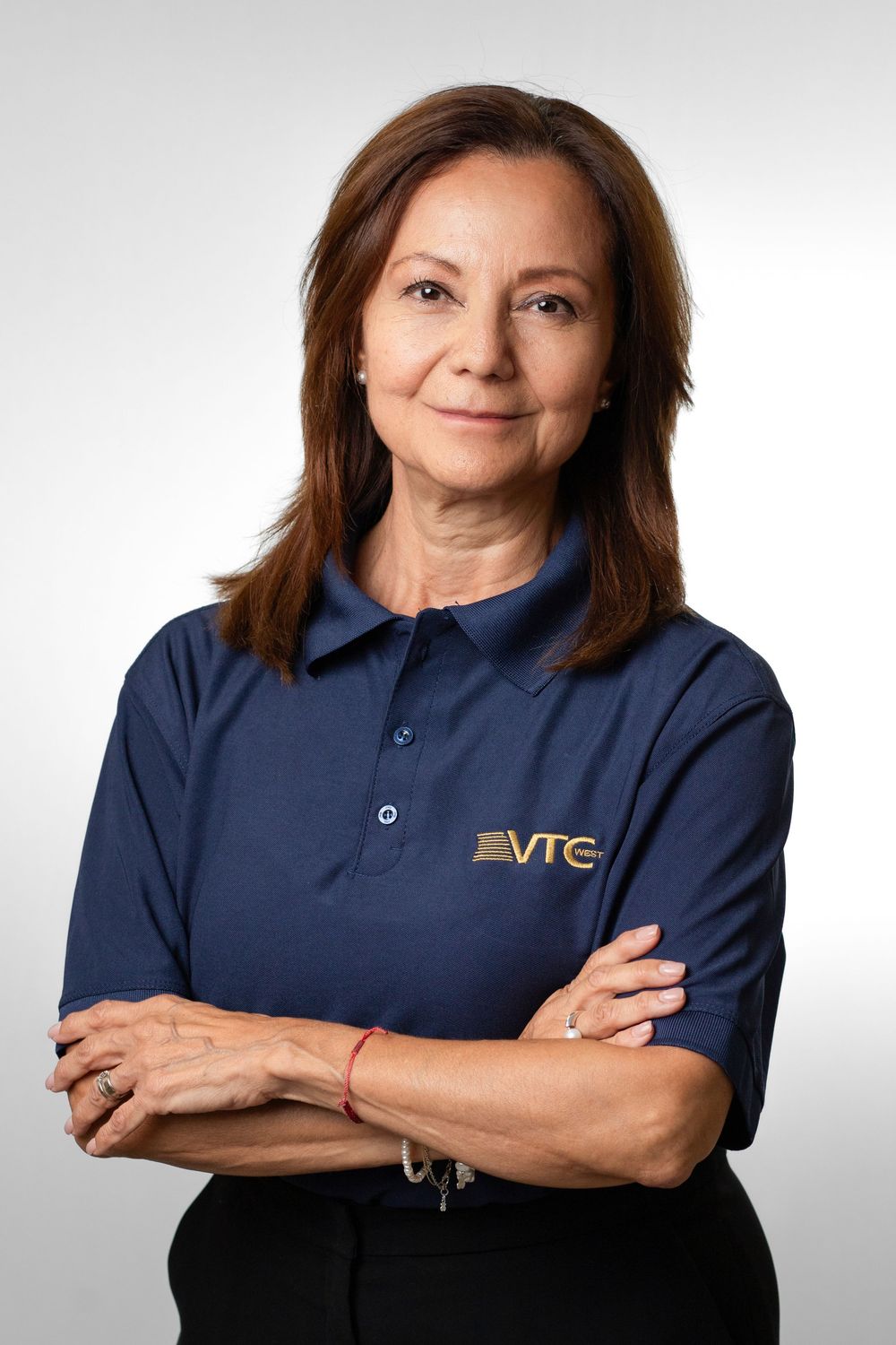 Professional headshot of someone wearing a navy blue polo shirt with VTC logo against light gray background.